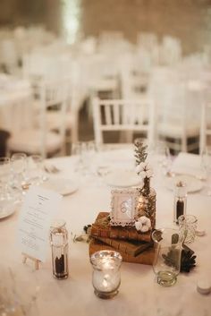 the table is set up with candles, books and other items for an elegant wedding reception