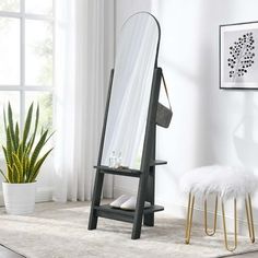 a mirror sitting on top of a wooden stand next to a potted plant in a living room