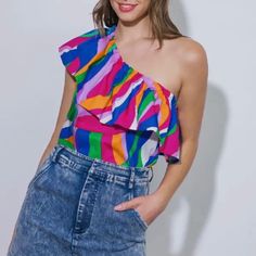 This Pop Of Color Top Is Perfect For Warm Weather. The Elastic Ruffle One Shoulder Design Allows You To Show Off A Tan Or Maybe A Tattoo! The Top Is 100% Cotton, Meaning It's Washable And Comfortable And Has No Stretch In The Fabric. We Love It Paired With Jeans Or Jean Shorts, Give It A Front Tuck! It Also Looks Great With A Wide Leg White Pant. 24" Length Chic Multi-colored Summer Tops, Chic Multicolor One-shoulder Top, Colorful Chic Summer Tops, Chic Colorful Summer Tops, Summer Party Blouse With Vibrant Print, Chic One-shoulder Multicolor Top, Trendy One-shoulder Blouse For Summer, Trendy One-shoulder Summer Blouse, Pink One-shoulder Blouse