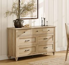 a wooden dresser sitting in front of a mirror on top of a hard wood floor