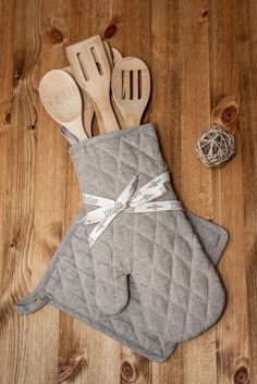 kitchen utensils and wooden spoons are laid out on the floor next to an oven mitt