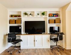 a home office with two computer screens on the wall