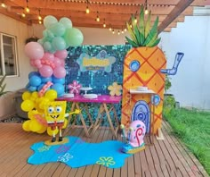 an outdoor party with pineapples, balloons and decorations on the deck for children's birthday