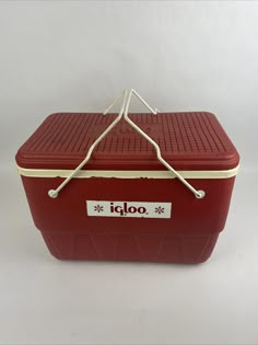 a red cooler sitting on top of a white table