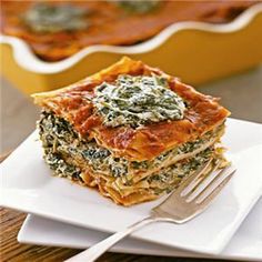 lasagna casserole with spinach and cheese on a square white plate