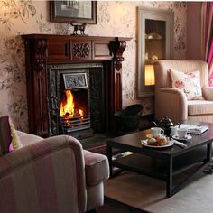 a living room filled with furniture and a fire place next to a couch in front of a fireplace