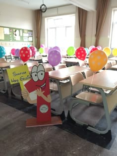 a classroom filled with lots of desks covered in balloons