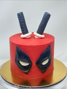 a cake with two swords sticking out of it's face on a plate that is sitting on top of a table