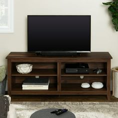 a flat screen tv sitting on top of a wooden entertainment center in a living room