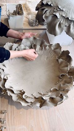 someone is working on an art project in the process of making a flower vase out of clay