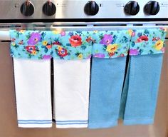 three tea towels hanging from the front of an oven