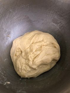 a ball of dough in a metal bowl