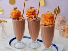 three glasses filled with food sitting on top of a table next to confetti