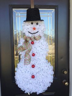 a snowman made out of toilet paper sitting in front of a door