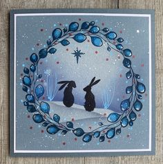 a christmas card with two rabbits in the snow