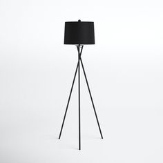 a floor lamp with a black shade on it's base and a white background