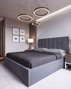 a modern bedroom with grey bedding and white carpeted flooring, two lamps hanging above the bed