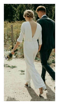 a man and woman walking down a dirt road