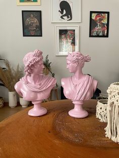 two pink busturines sitting on top of a wooden table