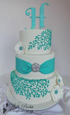 a three tiered cake decorated with blue and white flowers