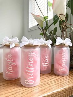 three pink mason jars with white bows on them