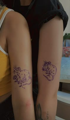 two people with tattoos on their arms