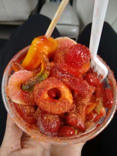 a person holding a glass bowl filled with fruit