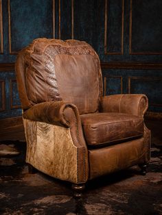 a brown leather recliner chair sitting on top of a carpeted floor next to a blue wall