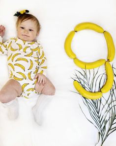 a baby is laying next to a fake banana