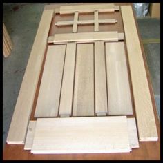 an unfinished wooden door is sitting on a table with some wood trimming around it