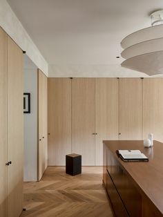 an empty room with wooden cabinets and a white vase on the table in front of it