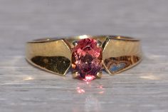 The Ostero: Ladies 14K Yellow Gold Tourmaline Cocktail Ring. Crafted in 14 karat yellow gold, this ladies' ring centers on an oval cut pink tourmaline. A concave gold band adds shine and dimension to this otherwise simple ring. Currently at a finger size 7.75, this ring can be resized for an additional charge upon request. Love this piece, but don't have the money to spend right now?  We offer FREE layaway on every item in our shop.  With just 20% down, take one full year (interest-free) to pay Oval Sapphire Tourmaline Ring For Formal Occasions, Formal Oval Sapphire Ring With Tourmaline, Formal Oval Sapphire Ring, Engagements Rings, Maximalist Jewelry, Graduation Ring, Graduation Rings, Gold Sign, Simple Ring