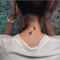 a woman with a bird tattoo on her neck