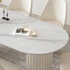 a marble dining table with white chairs and a magazine on it's end shelf