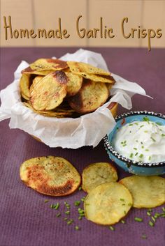 homemade garlic crispes with sour cream and chives in a blue bowl on a purple tablecloth