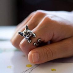 a person's hand with a ring on it that has an animal head in the middle