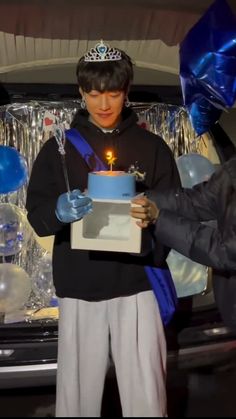 a man holding a cake with a candle in it