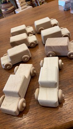 wooden toy cars are arranged on a wood table in the shape of a train or car