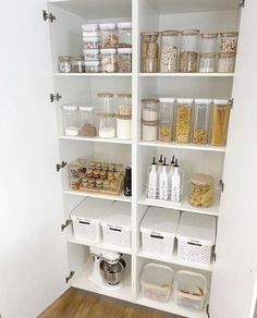 an organized pantry with white shelving and lots of food on the shelves in it