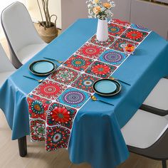 a blue table cloth with red, white and blue designs on it is sitting on a dining room table