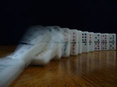 dominos are lined up on a wooden table