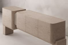 a bench made out of concrete sitting on top of a white floor next to a wall