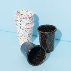 two cups with sprinkles on them sitting next to each other in front of a blue background