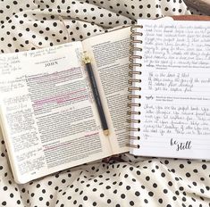 an open book with writing on it next to a black and white polka dot sheet