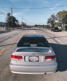 a silver car is parked on the side of the road