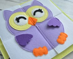 an owl made out of felt sitting on top of a piece of paper