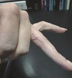 a woman's hand with a tiny tattoo on it