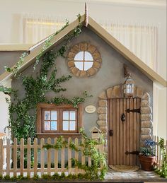 a doll house with ivy growing up the side of it and a white picket fence