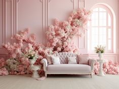 a living room with pink walls and flowers in vases on the floor next to a couch