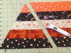 a pair of scissors sitting on top of an orange and black piece of fabric next to a ruler